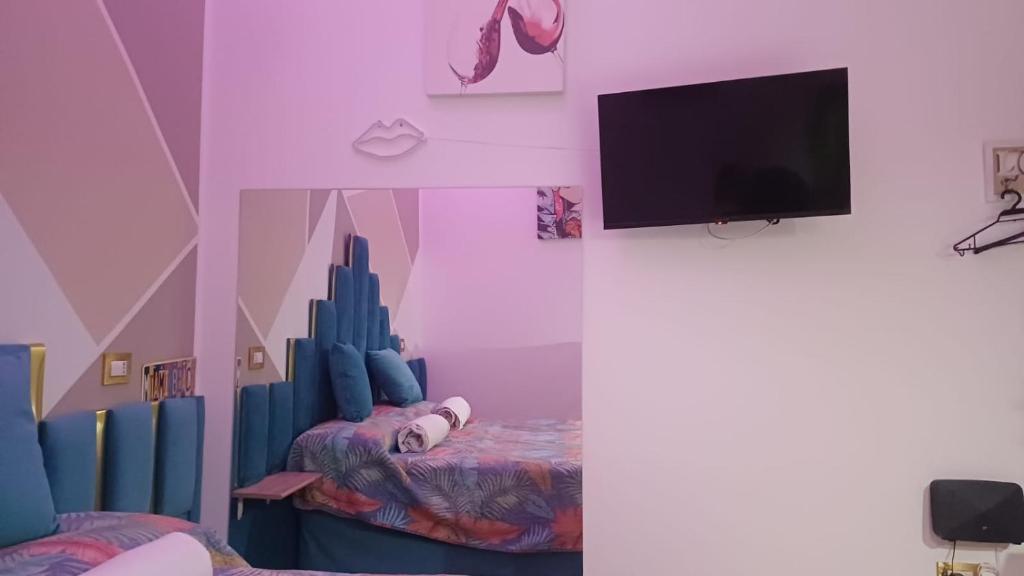 a room with a tv and a room with a bed at Suite Romeo in Bari