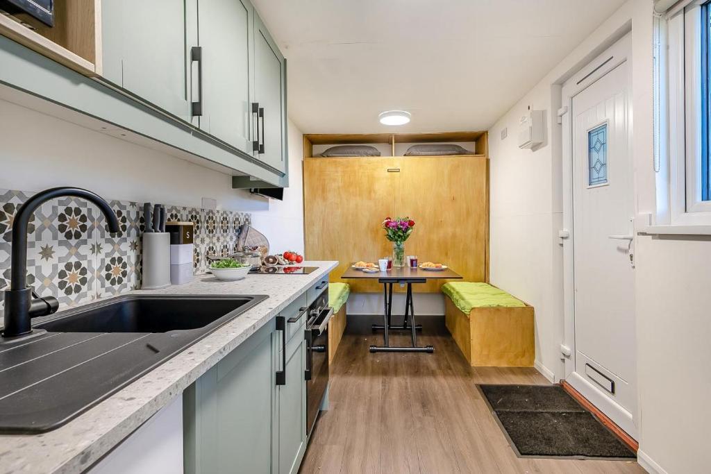 eine Küche mit weißen Schränken und einem Waschbecken und einem Tisch in der Unterkunft 1 Bed in Wellesbourne oc-c33029 in Hampton Lucy
