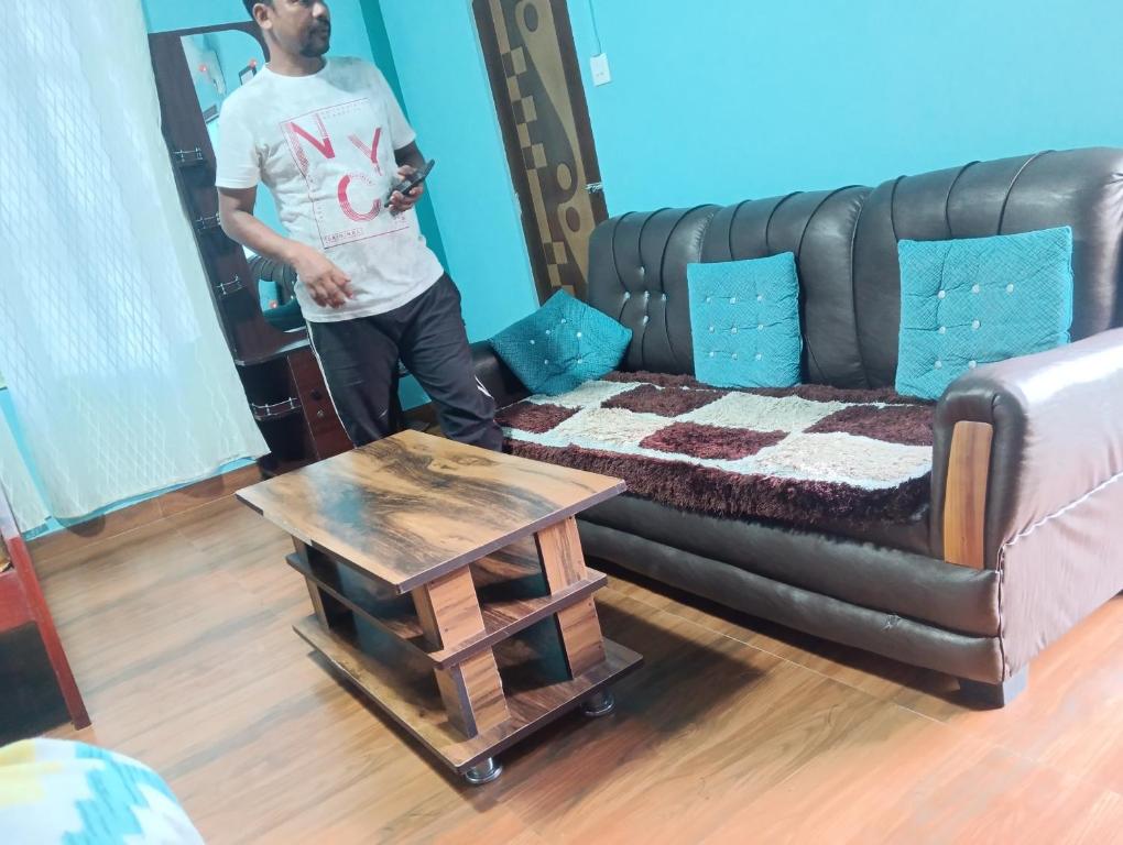 a man standing in a living room with a couch at deiphi and risa homestay in Pynursla