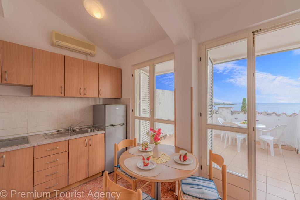 een keuken met een tafel en een eetkamer met uitzicht bij Miljenko in Novalja