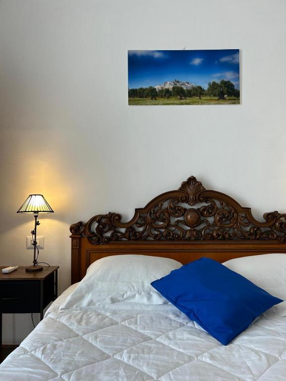 a bed with a blue pillow on top of it at stanza zaffiro azzurro in Ostuni