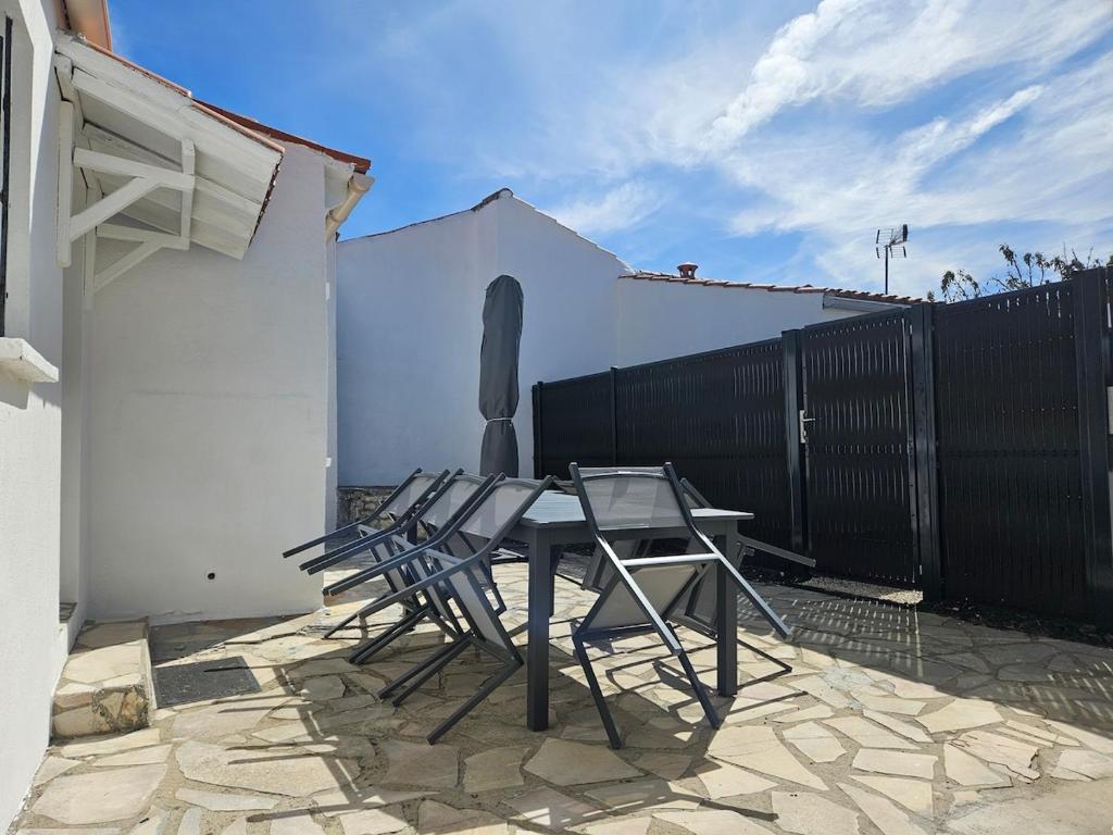 a patio with two chairs and a table and a fence at Le Grand Horizon Rochelais, plage à 5min, parking in La Rochelle