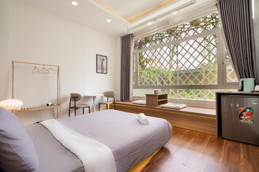 een slaapkamer met een bed en een groot raam bij V Living Lam Sơn in Ho Chi Minh-stad