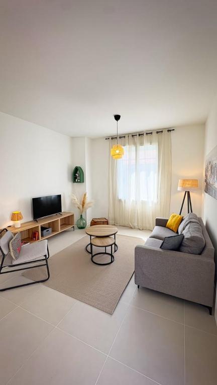 a living room with a couch and a table at Maison Du Marché, chaleureuse, proche de Île de Ré in La Rochelle