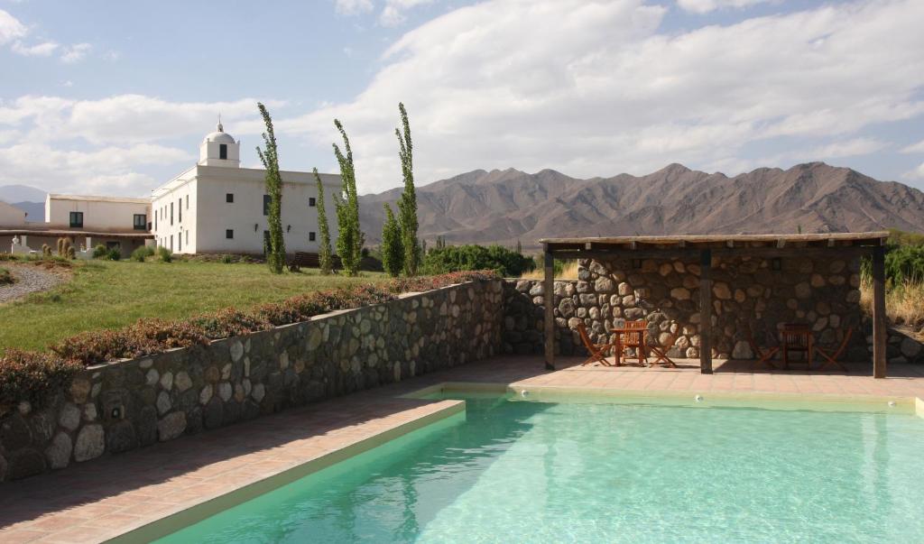 a large stone building with a swimming pool in front of it at La Merced Del Alto in Cachí