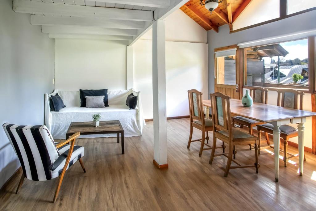 a dining room with a table and chairs and a bed at BOG Departamento centro - Vista Horizonte in Villa La Angostura