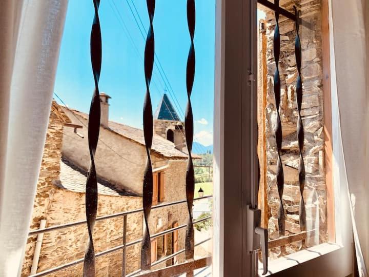 une fenêtre ouverte avec vue sur une église dans l'établissement Apartamento en Girona, à Tor