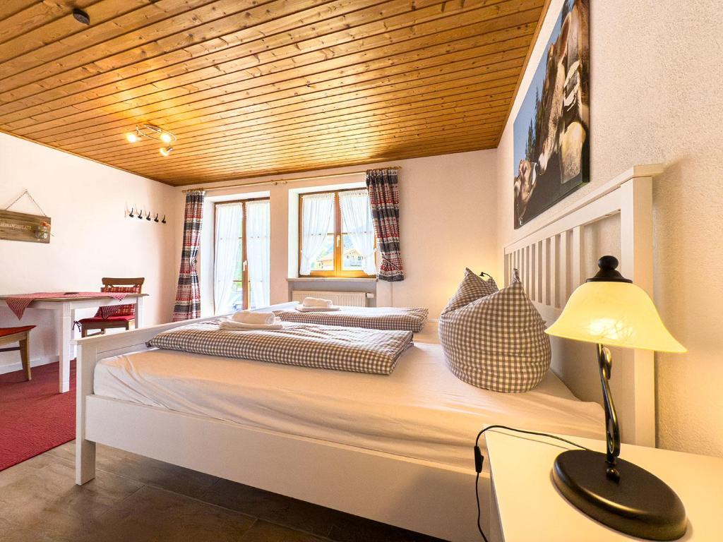 een slaapkamer met een groot bed met een lamp op een bureau bij Landhaus Steibis - Seelekopf in Steibis