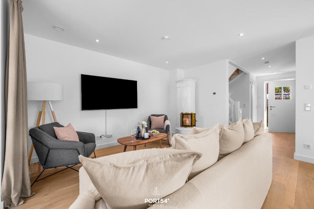 a white living room with a couch and chairs at Villa Tinnum Sylt in Tinnum