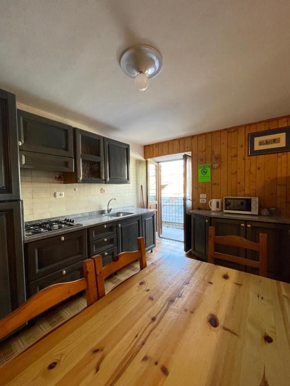 a kitchen with black cabinets and a wooden floor at Appartamento Blu - Cerise in Cerise