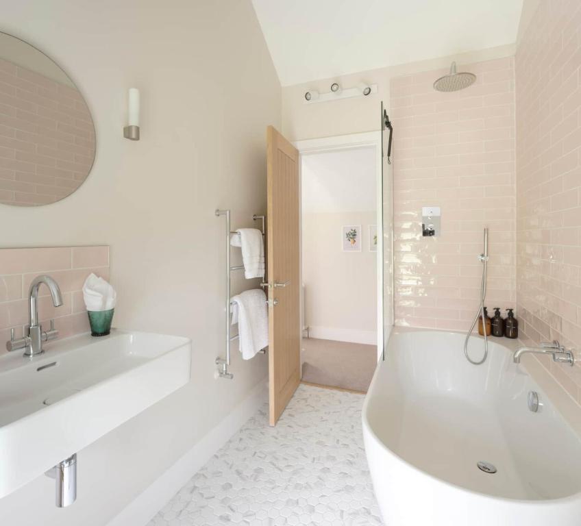 Un baño blanco con bañera y lavabo. en Limeworks Hemmel, en Holburn
