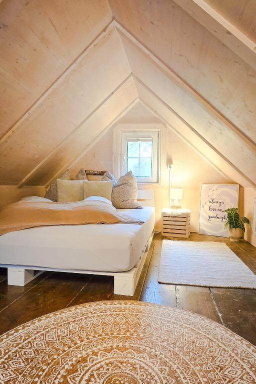 a bedroom with a large bed in the attic at Wöschhüsli mit Sauna, Alpenruhe nahe Bodensee in Rheineck
