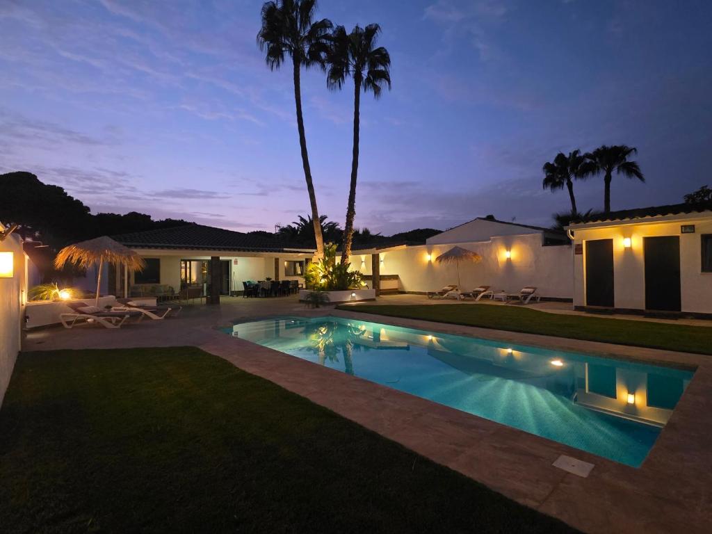 a villa with a swimming pool at night at La caprichosa in Chiclana de la Frontera