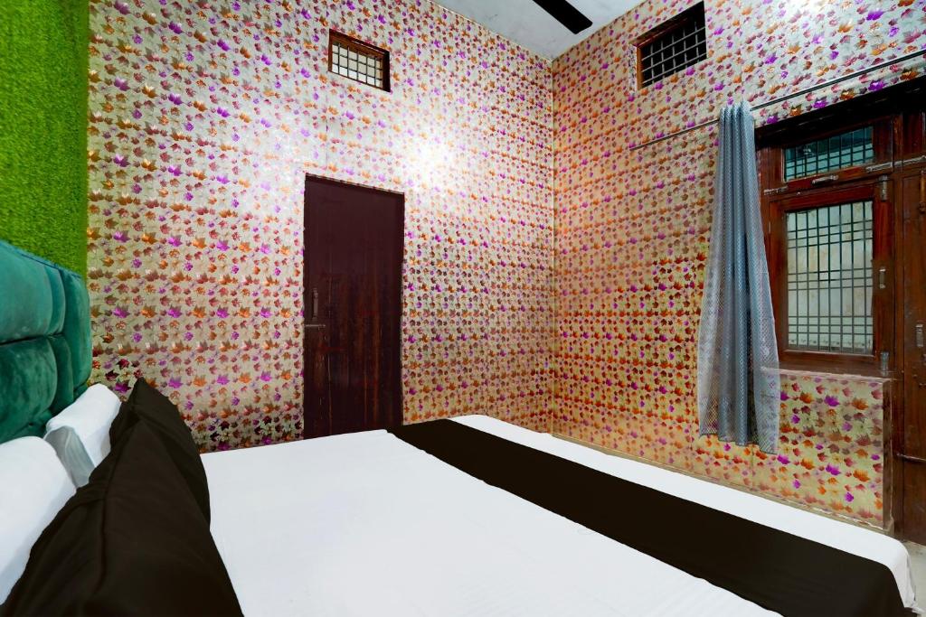 アリーガルにあるSPOT ON GANGA HOTELのカラフルな壁紙のベッドルーム1室(ベッド1台付)