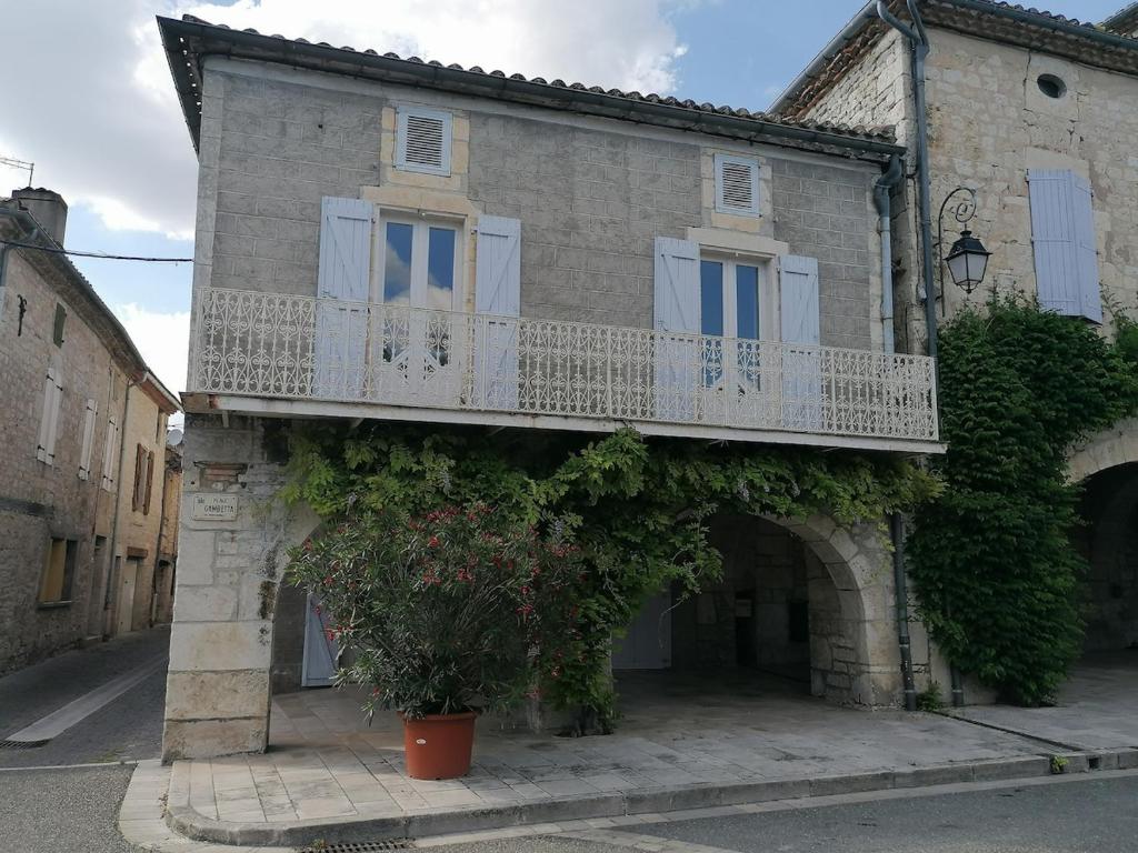 un bâtiment avec un balcon sur le côté dans l'établissement Un Noël paisible, entre douceur,magie et surprise !, à Castelnau-de-Montratier
