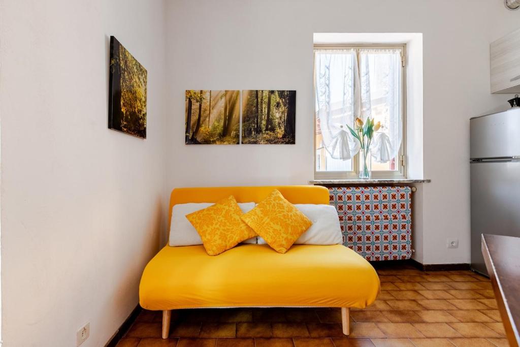 a yellow couch in a kitchen with a window at Ca’ Ruset in Roccaforte Mondovì