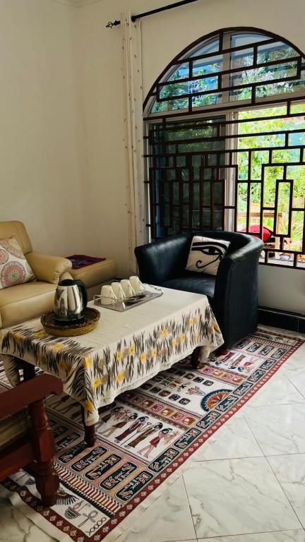 a living room with a table and a chair at Amoy River Lodge in Moshi