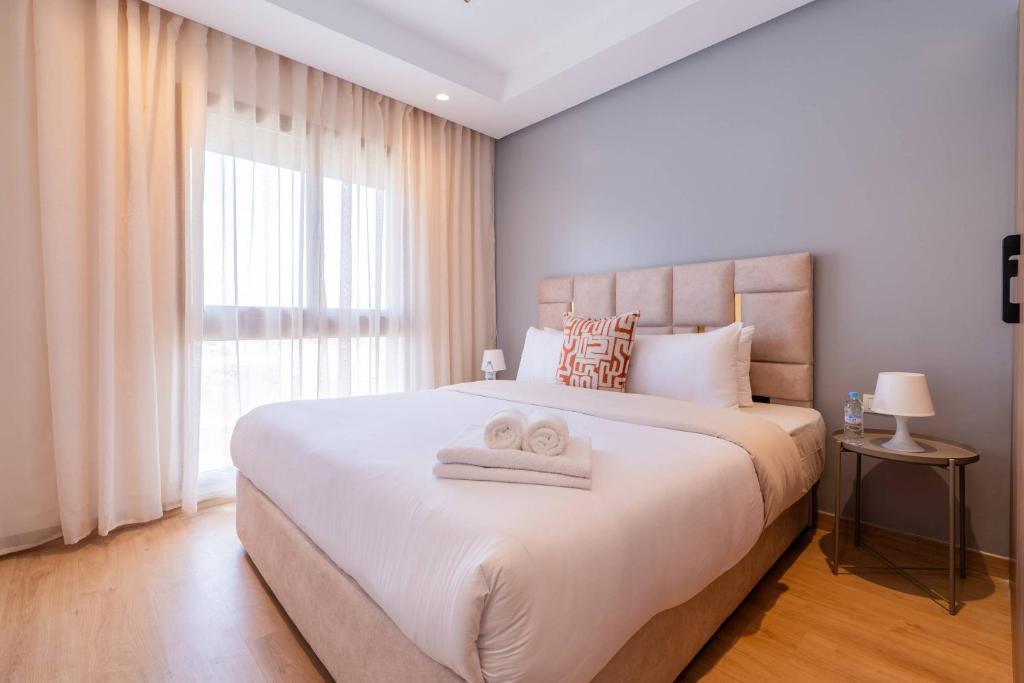 Un dormitorio con una cama grande con dos toallas encima. en Modern Apartment Pool Balcony & Comfort, en Aïn Harrouda