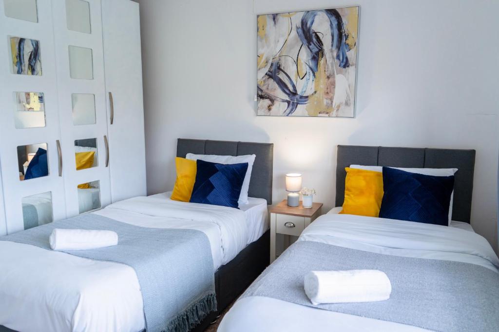 two beds sitting next to each other in a room at Tranquil Walsall Retreat - 4 Bedrooms in Bloxwich