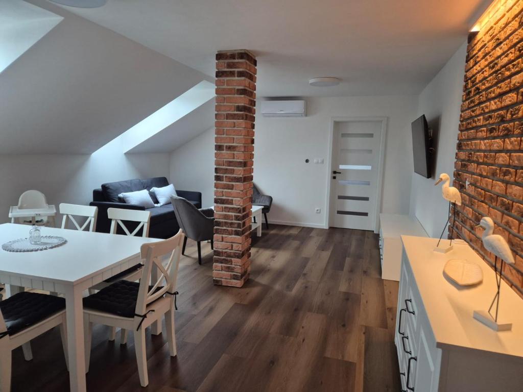 sala de estar y comedor con pared de ladrillo en Apartmán By One, en Banská Štiavnica