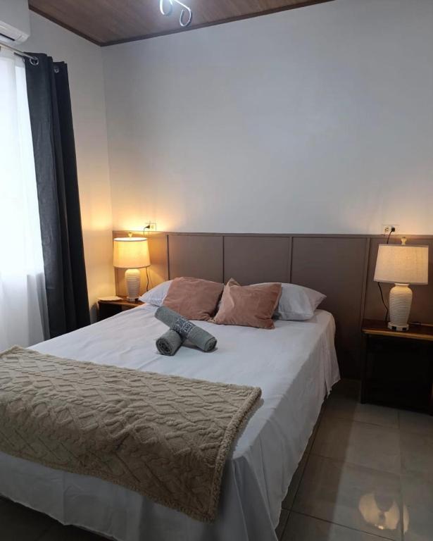 une chambre avec un grand lit blanc avec deux lampes dans l'établissement Coral House Fortuna, à Tanque