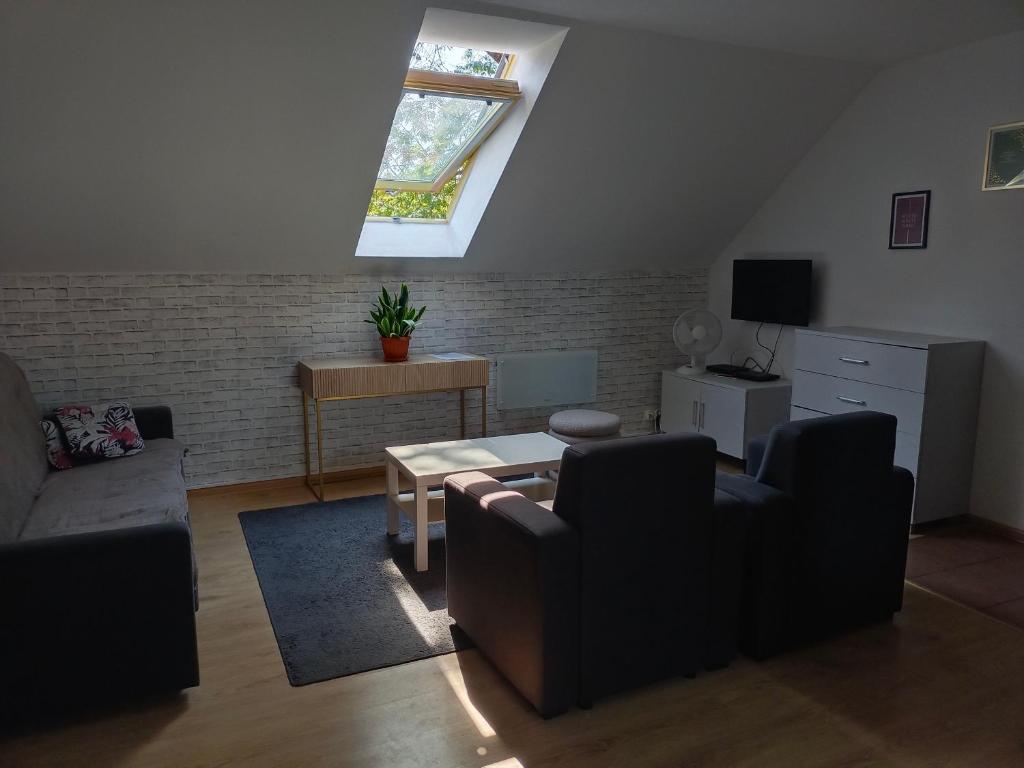 Una sala de estar con un sofá y una ventana. en Sunny Grey, en Żerniki Wroctawskie