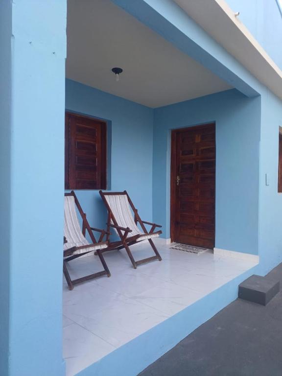 2 sillas sentadas en una habitación con una pared azul en Vila Velho Chico, en Bom Jesus da Lapa