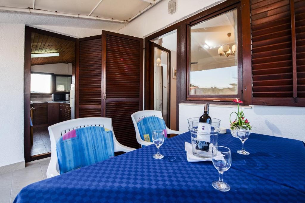 - une table bleue avec une bouteille de vin dans l'établissement Apartments Valdibora, à Rovinj