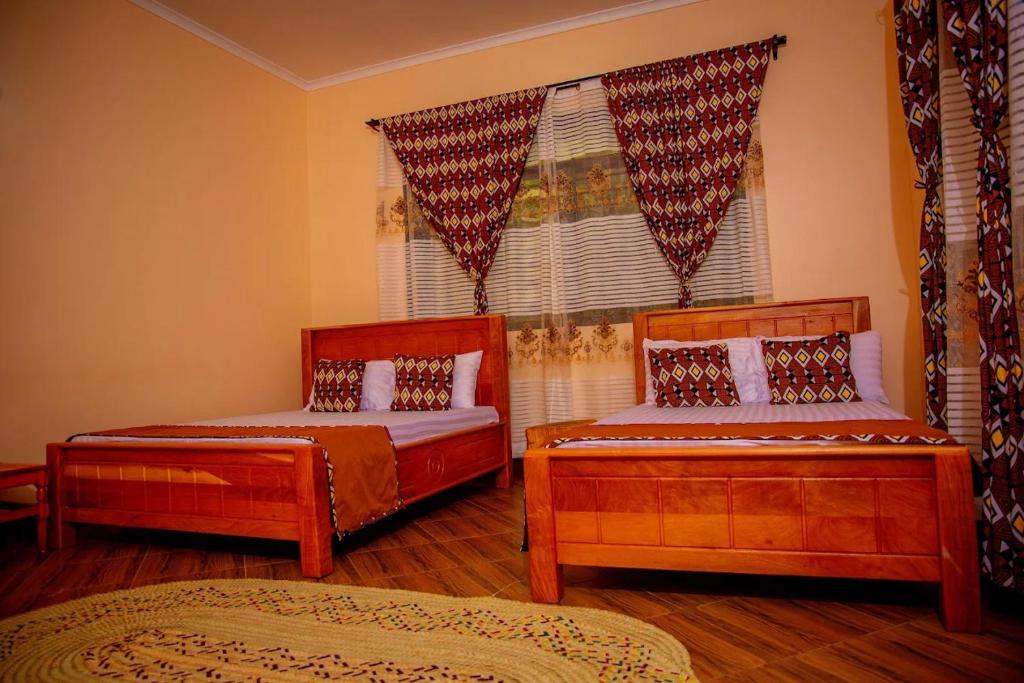 a bedroom with two beds and a window at Materuni Home Stay in Uru East