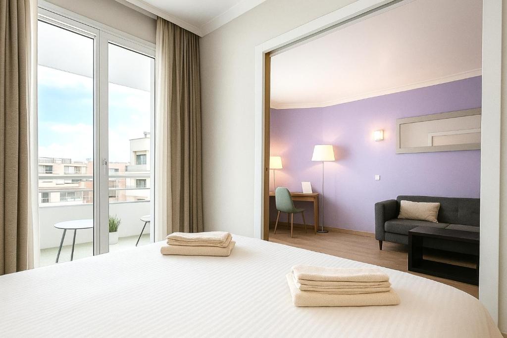 une chambre avec un lit et un salon dans l'établissement MyCityHaven Paris La Défense, à Courbevoie