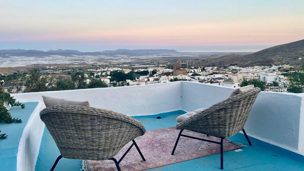 2 chaises assises sur un balcon donnant sur la ville dans l'établissement Cuevas Soluna en Solara, voor max 8 personen, à Níjar