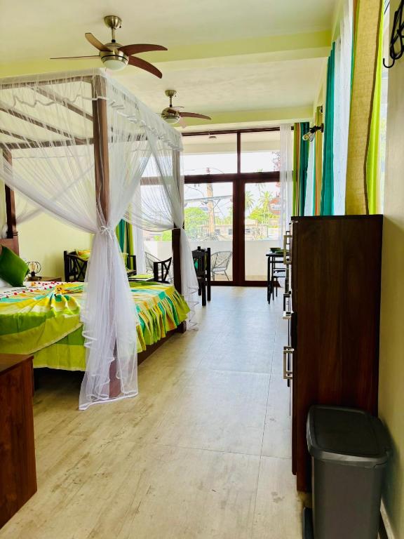 a bedroom with a bed with a mosquito net at Dinewa Apartment in Aluthgama
