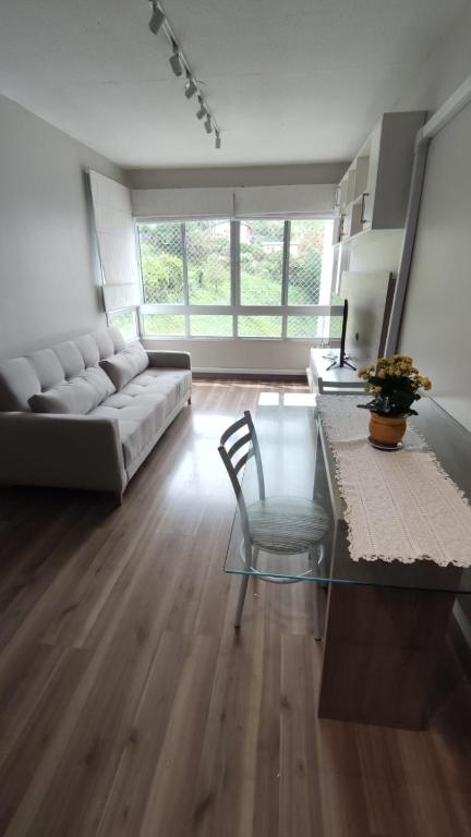 a living room with a couch and a glass table at Apartamento completo e com ar-condicionado in Bento Gonçalves