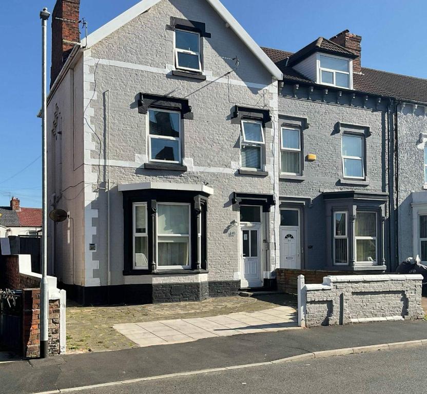 ウォラシーにあるMARLEY MANSIONS APARTMENT Clarendon FT3の通りに面した白い窓のある灰色のレンガ造りの家