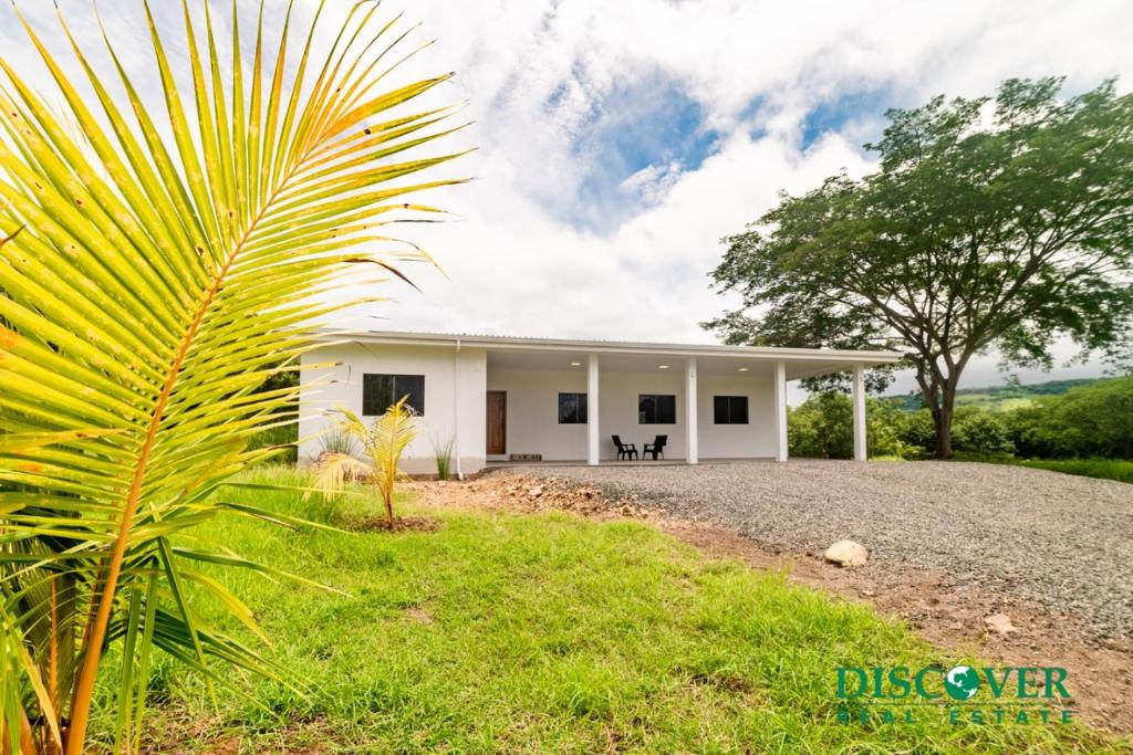 a palm tree in front of a white building at Nica Nest 3Br Eco Home Escamequita, NI in San Juan del Sur