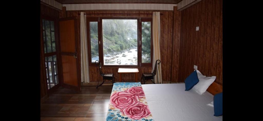 本贾尔Tirthan Valley Cockaigne的一间卧室，床上铺着一条玫瑰花纹的毯子。