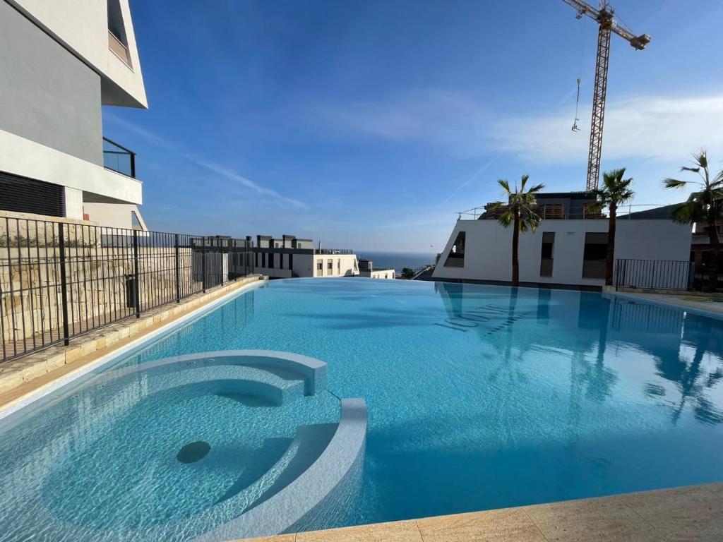 a large blue swimming pool in a building at Iconic Zuza in Gran Alacant