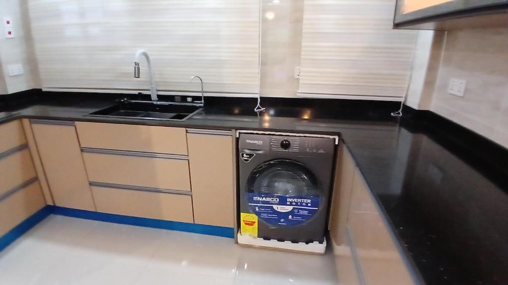 een wasmachine in een keuken naast een wastafel bij Beatrix Valley, 2 Bedroom Modern Luxury in Tema