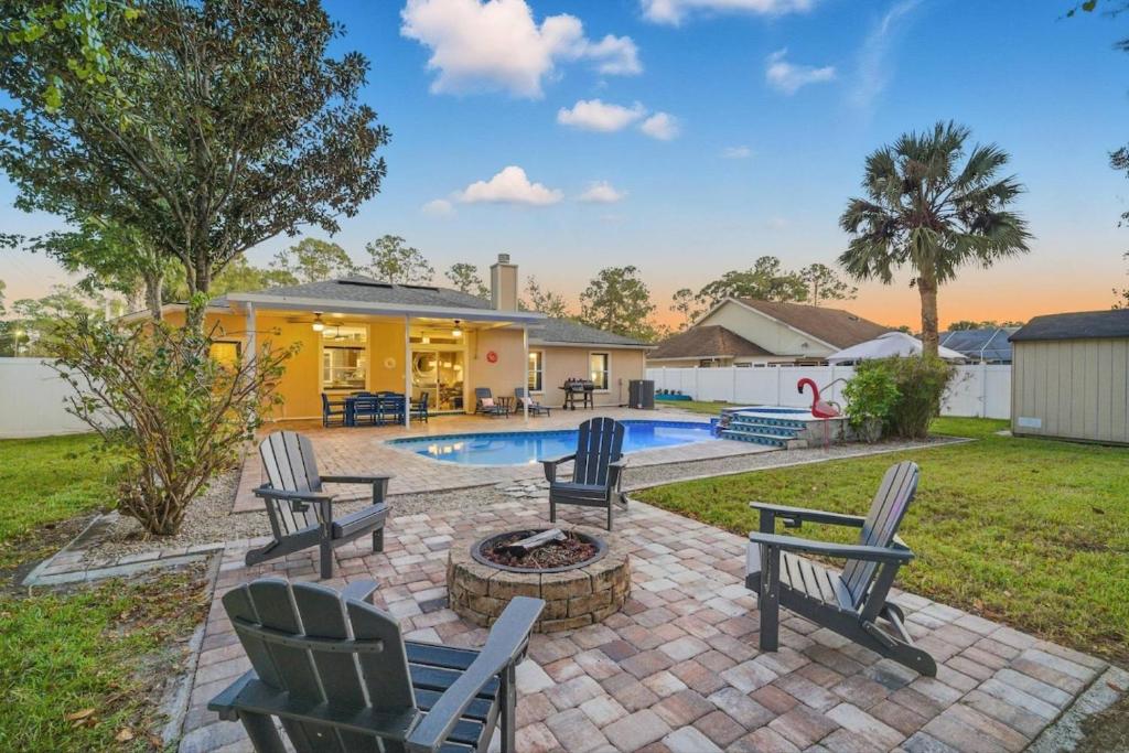 a patio with chairs and a fire pit in a yard at Castaway Cove | Palm Coast in Palm Coast