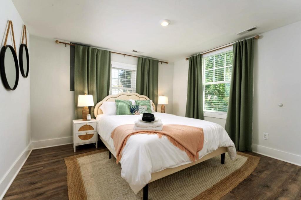 a bedroom with a large bed with green curtains at Downtown Retreat, 5BR Game Room & Pet Friendly in Wilmington