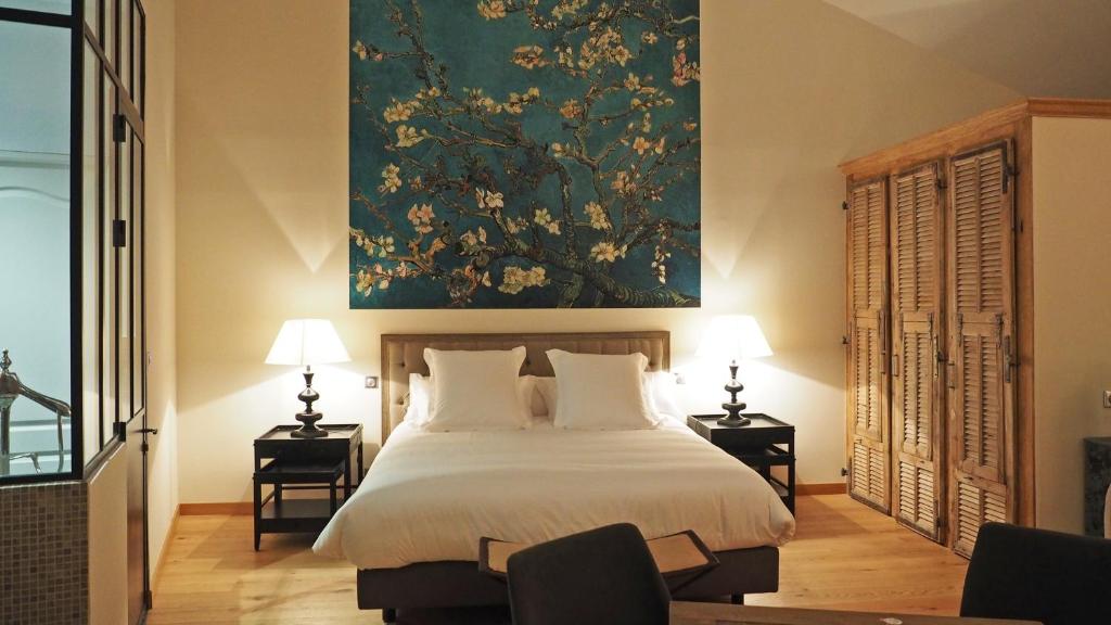 サン・レミ・ド・プロヴァンスにあるChambre d'Hôtes Les Variétésのベッドルーム1室(壁に絵画が描かれたベッド1台付)