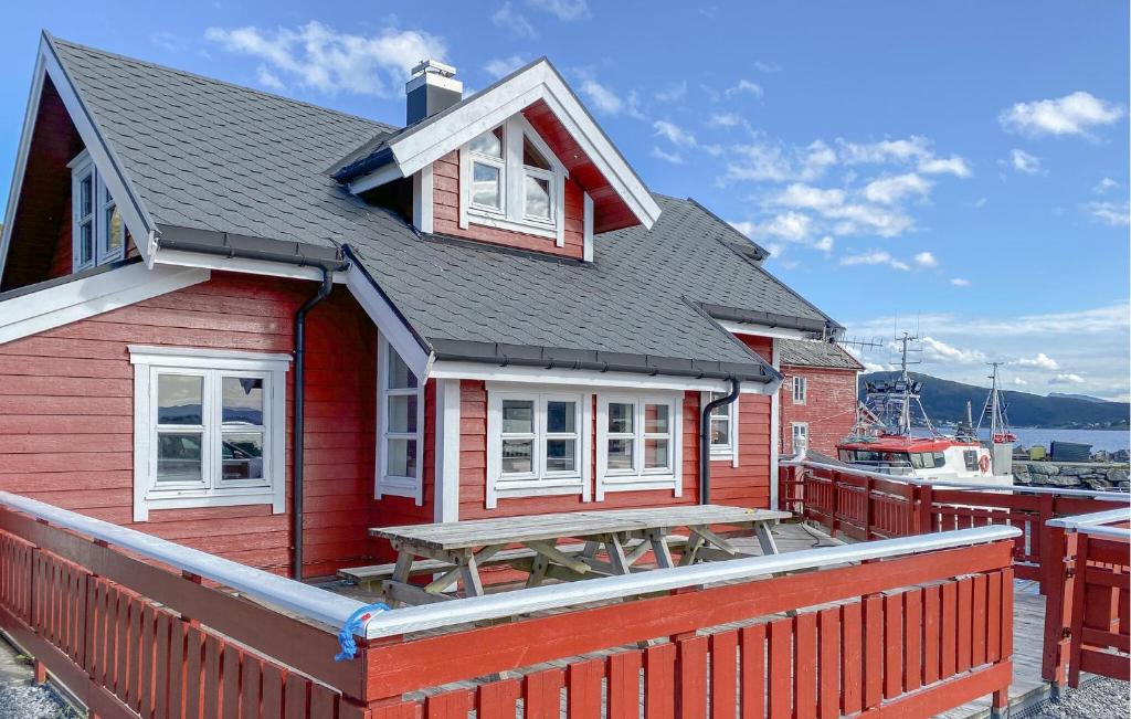 une maison rouge avec une table de pique-nique sur une terrasse dans l'établissement 4 Bedroom Lovely Home In Leinøya, à Fosnavåg