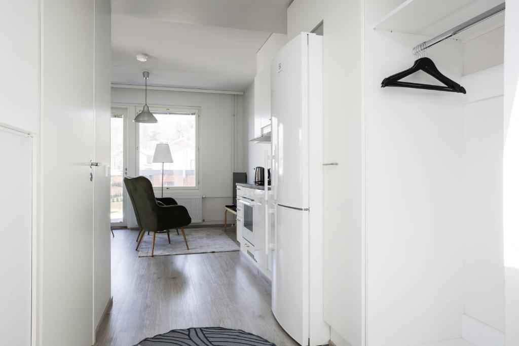 a kitchen with white cabinets and a chair in a room at Convenient Apartment for 3 in Masala