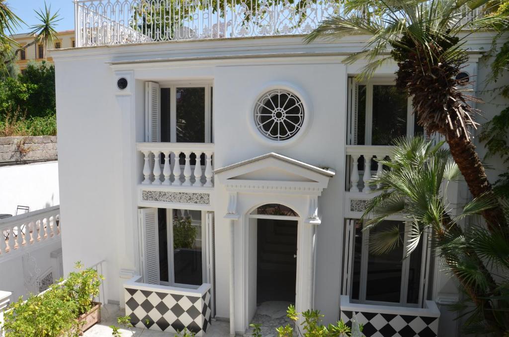 uma casa branca com uma palmeira em frente em Muta House em Sorrento