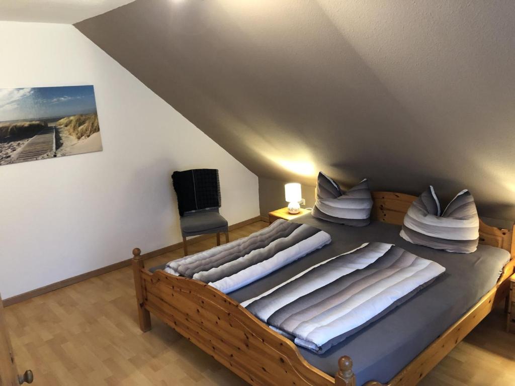 a bedroom with a large wooden bed with pillows at Ferienhaus Ahoi in Hooksiel