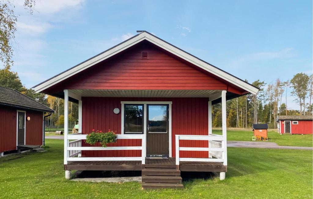 2 Bedroom Lovely Home In Byxelkrok في بيكسلكروك: بيت احمر وباب ابيض ورواق