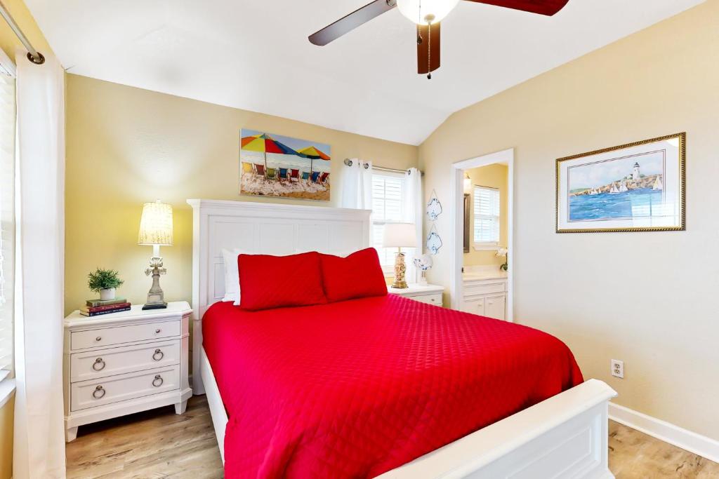 ein Schlafzimmer mit einem Bett mit einer roten Decke in der Unterkunft Prime Gulf Views Large Deck Pet Paradise in Bolivar Peninsula