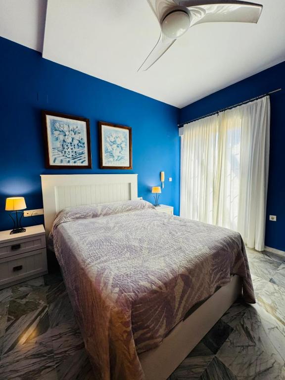 a blue bedroom with a bed and a blue wall at Signature Stay Apartments 6 in Almuñécar