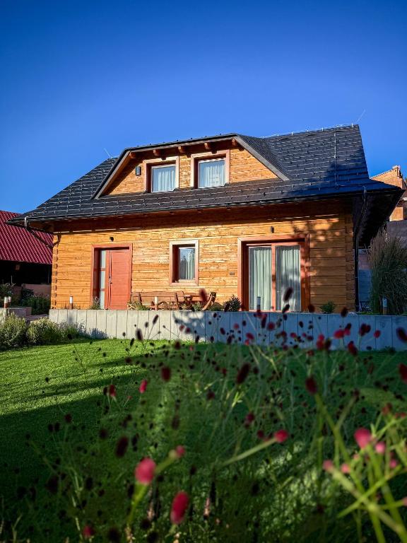 a house with a yard with flowers in front of it at Chata Vojtek in Terchová