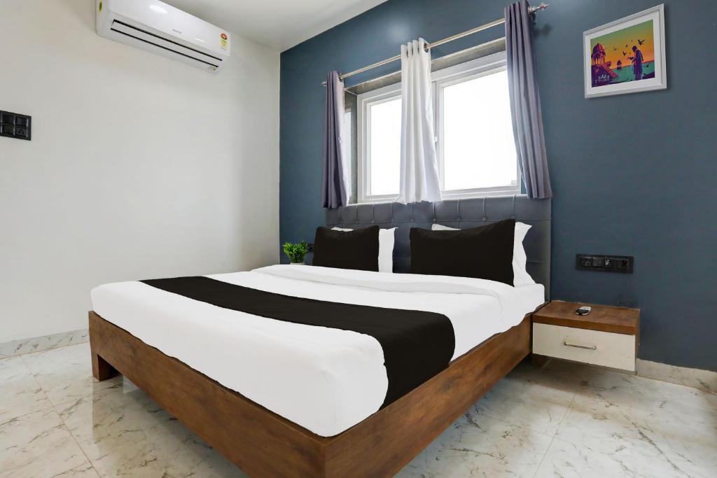 ein Schlafzimmer mit einem großen Bett mit einer blauen Wand in der Unterkunft HOTEL O ANUSHTHAN in Jabalpur